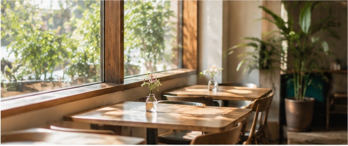 植物と窓のあるカフェ店内